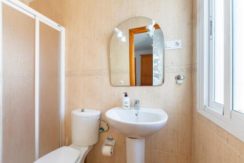 a bathroom with a toilet and a sink and a mirror at Maracas 2 in El Pozo de los Frailes