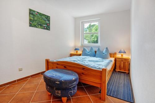 a bedroom with a bed and a stool and a window at Haus Seeadler Wohnung 11 in Koserow