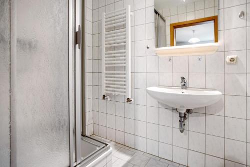 a white bathroom with a sink and a mirror at Haus Seeadler Wohnung 11 in Koserow