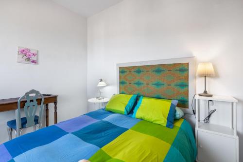 a bedroom with a colorful bed and a desk at Villa Los Aguacateros in Tazacorte