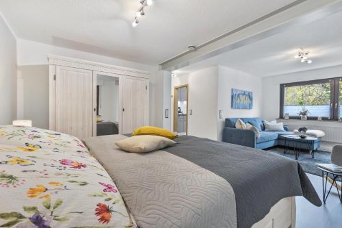 a bedroom with a bed and a living room at Ferienwohnung an der Volme in Meinerzhagen