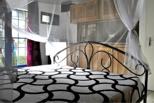 a bedroom with a bed with a black and white comforter at Appartement à Natangue 1 in Saly Portudal