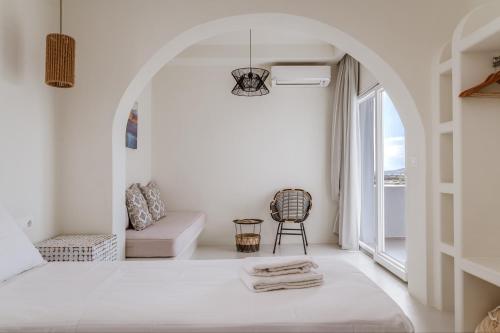 a white room with a bed and a window at Aeolos Villa Erato in Agkidia
