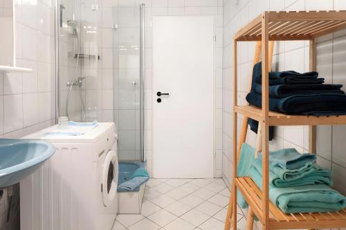 a bathroom with a washing machine and a shelf with towels at Petit Bijou in March