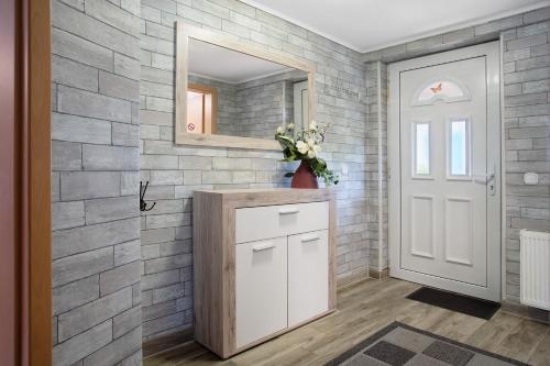 a bathroom with a stone wall and a mirror at Bungalow Bei Rügen in Sundhagen-Niederhof