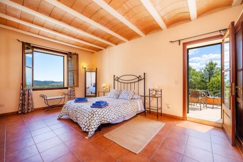 ein Schlafzimmer mit einem Bett in einem Zimmer mit Fenstern in der Unterkunft Finca Moscari in Moscari