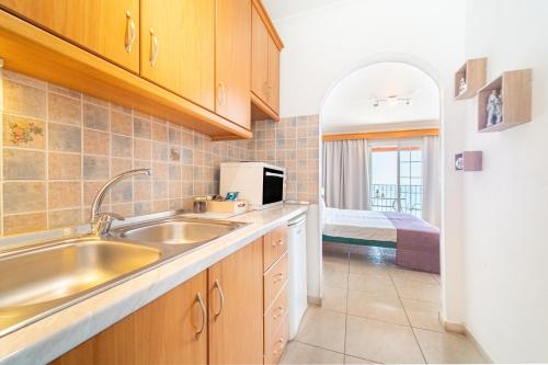 a kitchen with a sink and a microwave at Spyridoula Studio 13 in Paleokastritsa