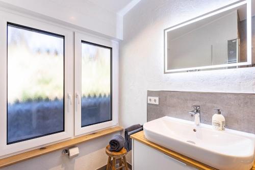 a bathroom with a sink and two windows at Ferienhaus Wiese in Schmallenberg