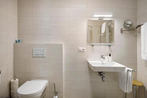 a white bathroom with a toilet and a sink at Appartement Mia in Ihrlerstein
