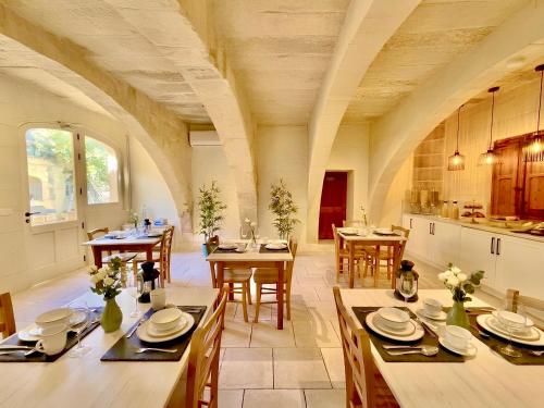 a large kitchen and dining room with tables and chairs at Ta' Matmura Boutique B&B in Għarb