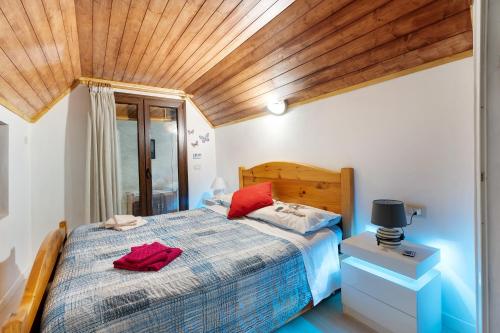 a bedroom with a bed and a wooden ceiling at Casa del sole in Toceno