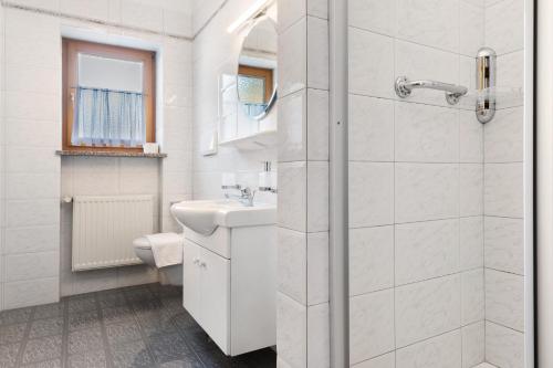 a white bathroom with a sink and a shower at Mayr Apartments Zwei in Plaus