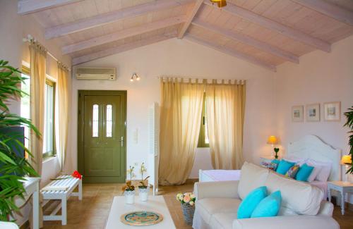 a living room with a white couch and blue pillows at Villa Kochilaki Ideales Resort in Kefallonia