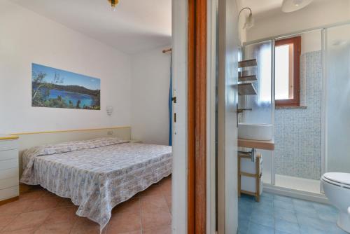 a bedroom with a bed and a sink and a toilet at Appartamenti Bonalaccia in Campo nell'Elba