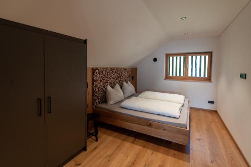 a bedroom with a bed with white sheets and a window at Hofer Hof Spieler in Lagundo