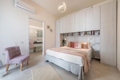 a bedroom with a large bed and a purple chair at La Casa dei sognatori in Villasimius