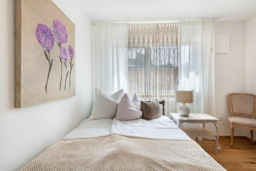 a bedroom with a bed and a window with purple flowers at bei Thérèse - Große Wohnung Eg in Miltach