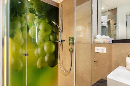 a bathroom with a shower with green grapes on the wall at Die Ferienwohnung in Reichenau