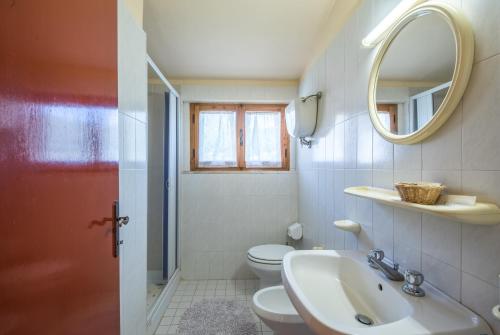 a bathroom with a sink and a toilet and a mirror at Podere del Pereto Bio- 202 in Rapolano Terme
