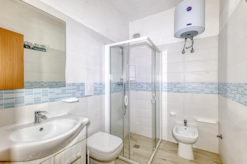 a bathroom with a sink and a toilet and a shower at Appartamento Luce sulla spiaggia in Torre San Giovanni Ugento