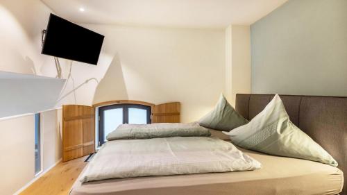 a bedroom with a bed with a television on the wall at Die Ferienwohnung in Reichenau