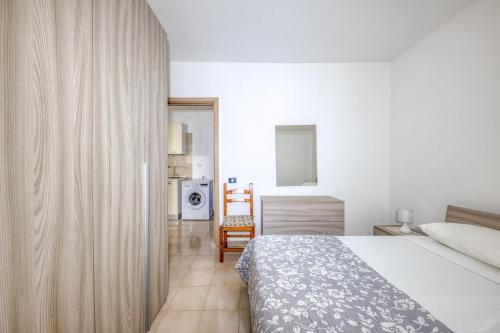 a hotel room with a bed and a kitchen at Appartamento Luce sulla spiaggia in Torre San Giovanni Ugento