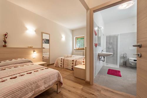 a hotel room with two beds and a bathroom at Nonno Bigi Papavero in Tremosine Sul Garda