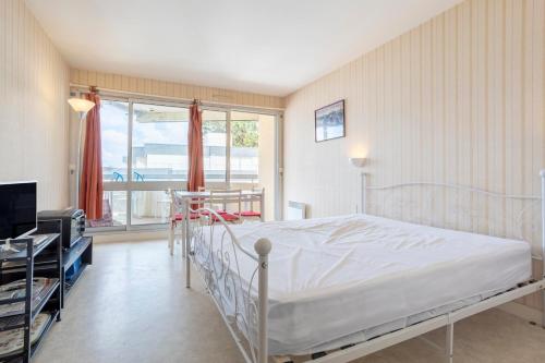 a bedroom with a bed and a large window at Studio vue mer - 50m de la plage in Bénodet