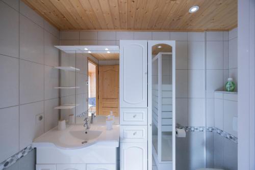 a bathroom with a sink and a mirror at Gîte La Clé Des Champs in Manigod