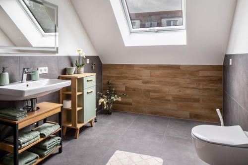 a bathroom with a sink and a toilet and skylight at Fewo Ebringen Weinbergblick in Ebringen