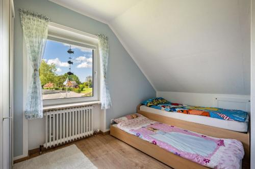 two twin beds in a room with a window at Ferienhaus Ostseetraum in Göhl