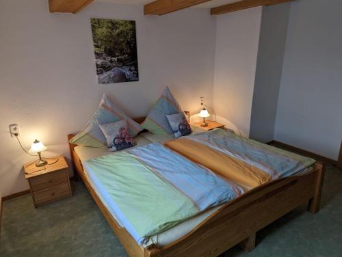 a bedroom with a large bed with two lamps at Ferienwohnung Stell in Altenbrak