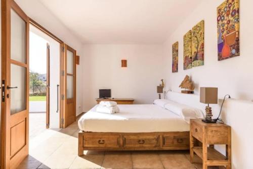 a bedroom with a large white bed and a window at Villa Dalt S Era in Santa Gertrudis de Fruitera