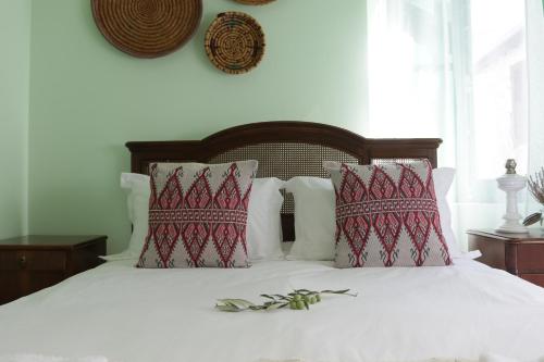 Un dormitorio con una cama blanca con almohadas rojas y blancas en To Konatzi tis Marikas tzai tou Yianni, en Kato Drys