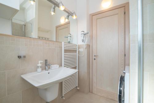 a bathroom with a sink and a mirror and a shower at C 306 Attico Puntavilla Mare in La Maddalena