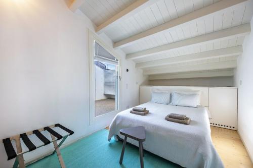 a bedroom with a large white bed and a window at Olinda House in Odeceixe