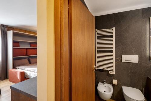 a bathroom with a toilet and a bedroom with a bed at Villa Elma - Livigno in Livigno