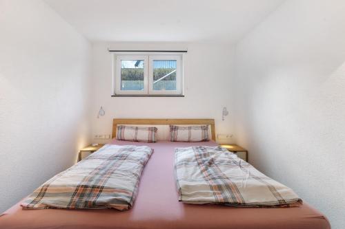 a large bed in a room with two windows at Goldbecker in Gaienhofen