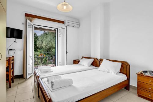 a bedroom with two beds and a balcony at Panorama apartment 2 in Póndi