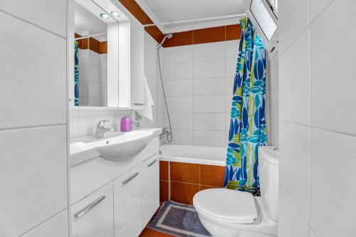 a bathroom with a toilet sink and a shower curtain at Panorama apartment 2 in Póndi