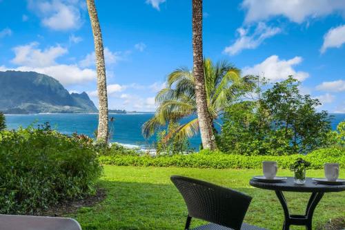 a table and chairs on a lawn with a view of the ocean at Ocean Bluff Gem in Princeville Beach Access Pool in Princeville
