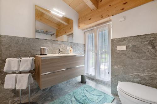 a bathroom with a sink and a toilet at La Villa di Ludo in San Cassiano
