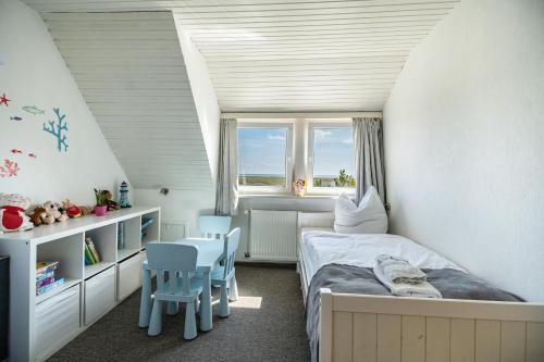 a bedroom with a bed and a table and chairs at Seehaus Juist in Juist
