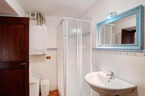 a white bathroom with a sink and a mirror at Antico Granaio in Vessalico