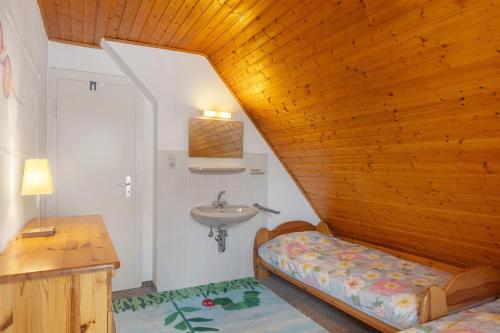 a bathroom with a sink and a bed in a room at Ferienwohnung Schloss-See-Bergblick in Waldeck
