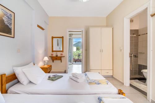 a bedroom with two beds and a bathroom at Studio Phaethon in Póndi