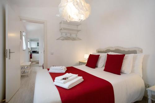 a bedroom with a large bed with red and white pillows at Páteo da Várzea 5 in Colares