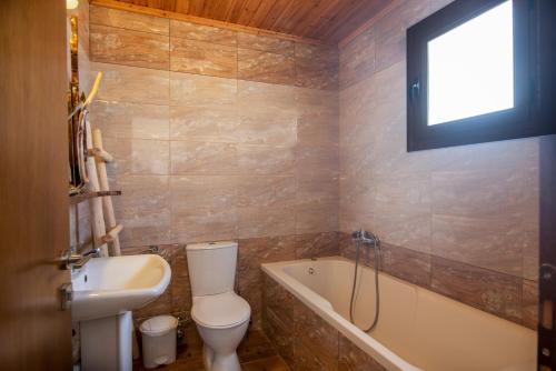 a bathroom with a toilet and a sink and a tub at Mirage Arillas Honeymoon Studio in Arillas