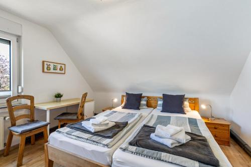 a bedroom with a bed with a desk and a chair at Ferienwohnung im Elsetal in Plettenberg