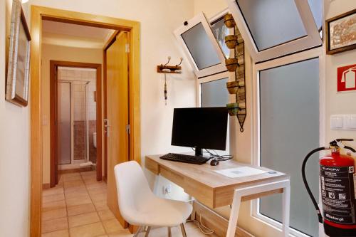 a room with a desk with a computer on it at Energia Dourada - Porto Santo in Porto Santo